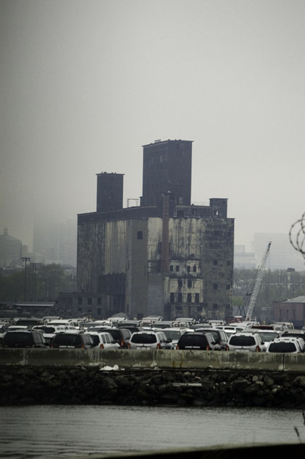 The black tower of the grain terminal looms over a parking
lot filled with SUV's.