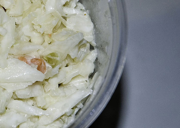 A close up of cole slaw, in a plastic container.
