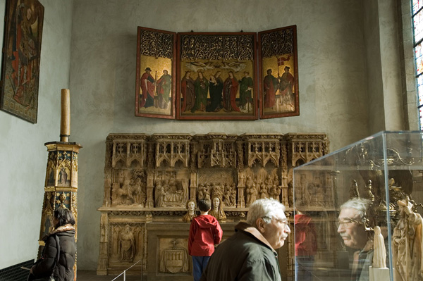 Museum visitors inspect objects.