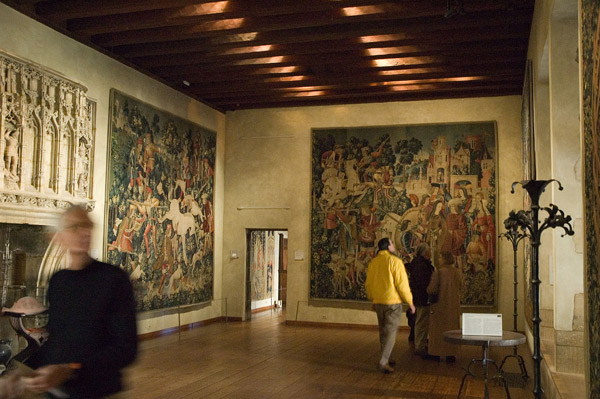 Visitors walk through a museums's room of renaissance
tapestries.