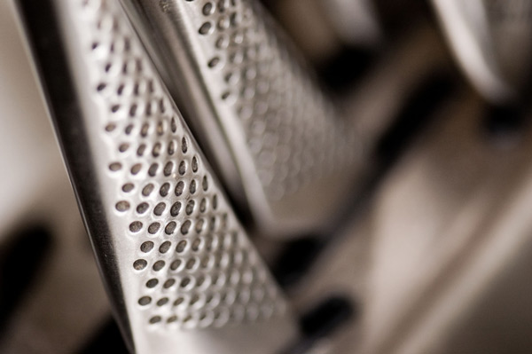 Stainless steel knife handles jut from a steel block.