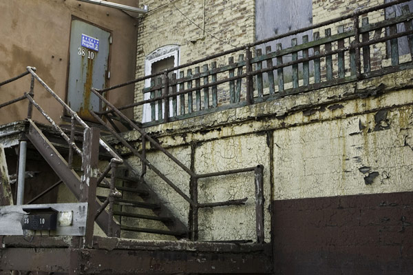 A wooden stairway leads past peeling paint to a
door.