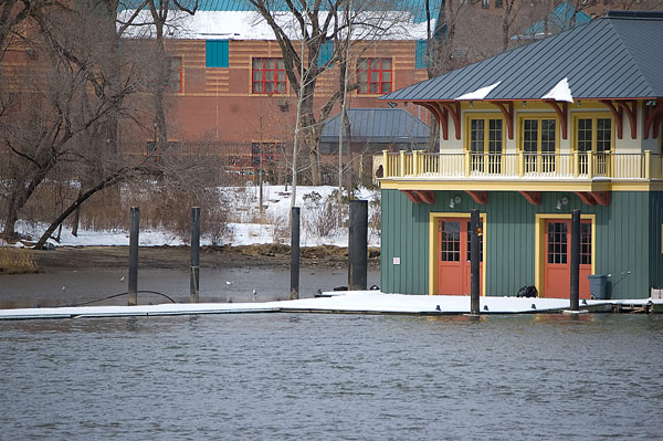 A multi-colored boat house sits amidst a river.