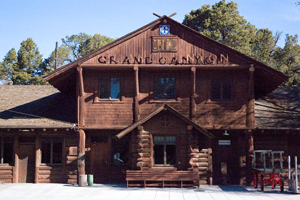 A wooden rail terminal stands in the bright morning sun.