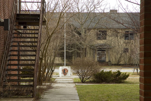 A white flagpole for the National Park Service stands
between vacant buildings.