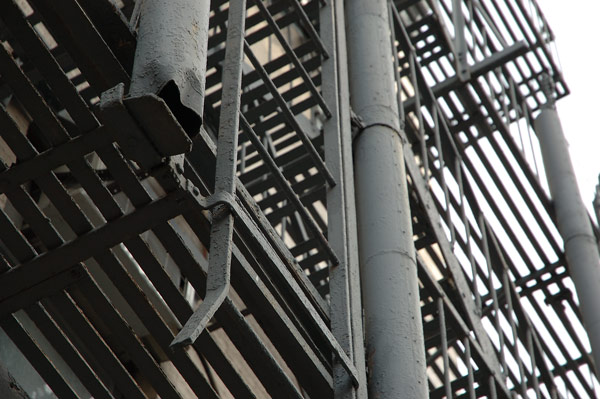 A grey fire escape, with its ladders and shafts for
counterweights.