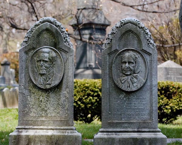 A pair of old tombstones, with faces of the husband and wife
carved on each.