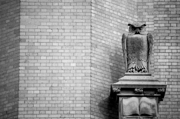 A
statue of an owl, standing over an open book.