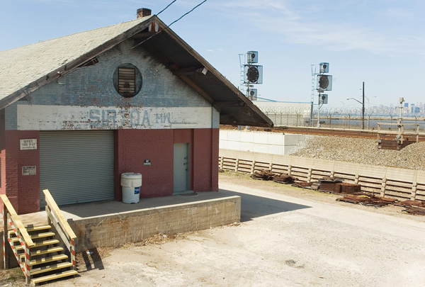 A building with large eaves and a loading dock in bright
sunlight.