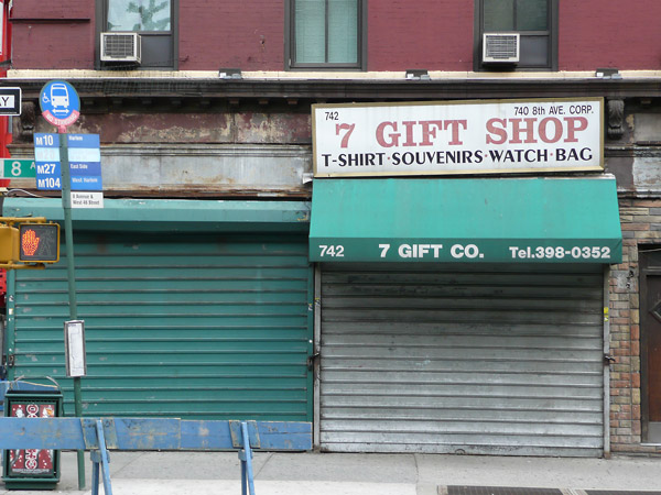 Two stores on a seedy block have their roll-fronts down.