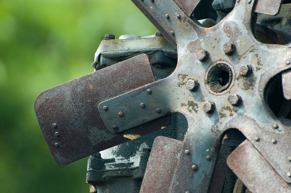 A fan on an engine block shows rust and age.