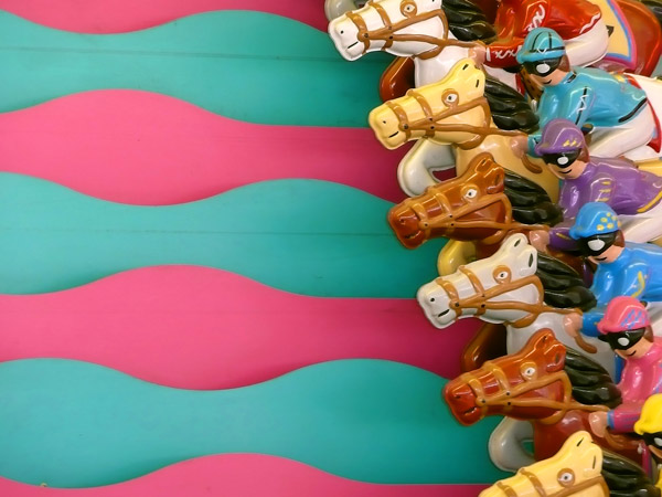 Brightly colored, metal jockeys and horses wait to
race.
