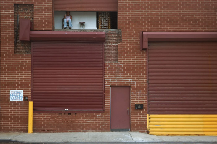 Above a loading dock, a worker takes a break.