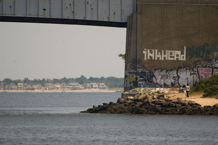 A man walks towards an overpass, from one body of water to
another.
