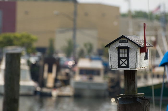 A mailbox, designed like a house, sits atop a pole.