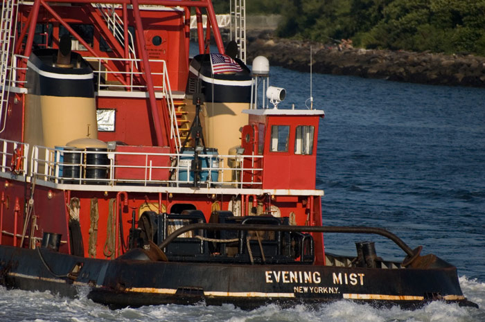 A brightly colored tugboat cuts through the waters of
New York Harbor.