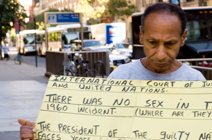 A man with a hand-lettered sign protests an obscure
grievance.