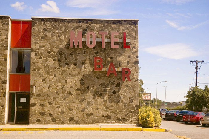 Bold red letters on a stone wall background, Motel Bar.