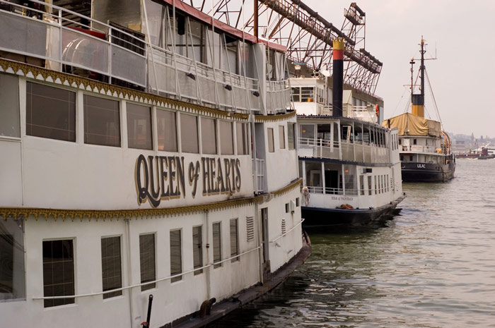 Three boats are moored to a pier in Manhattan.