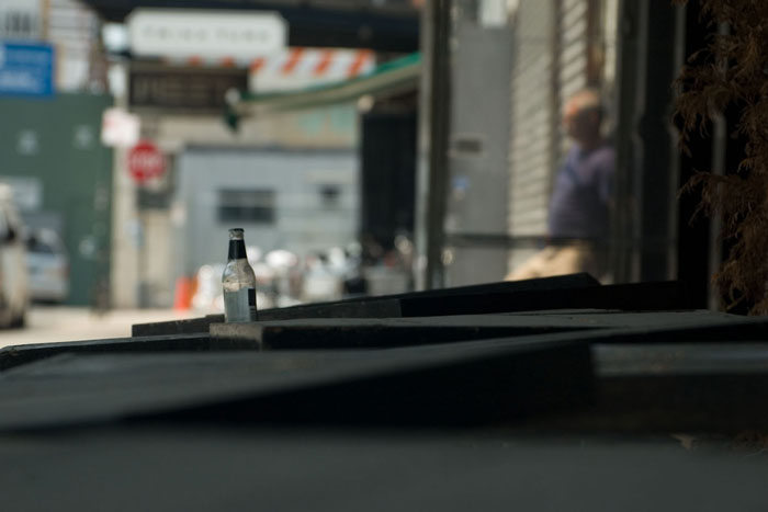A clear glass bottle on a table, with the background
blurred.
