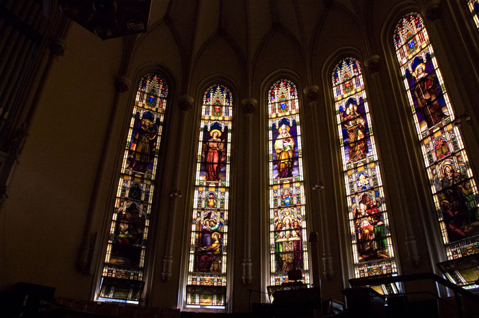 Tall, colorful church windows with light coming through.