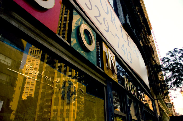 A storefront's windows reflects buildings.