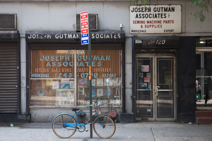 A blue bike is locked in front of a store with lots of
blue.