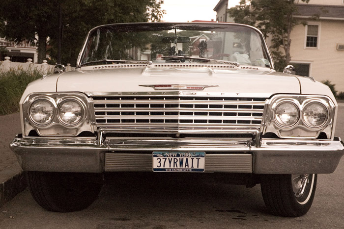 A classic Chevy's license plate reads '37YRWAIT.'