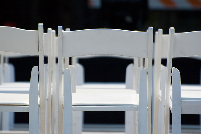 White chairs are set in rows for a reception.