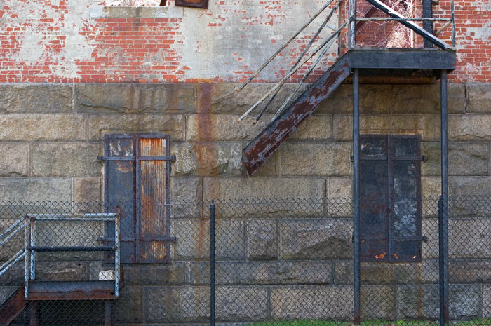 A metal stairway stands against blocks and bricks.