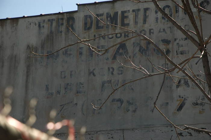 The remaining letters of a sign that advertised insurance.