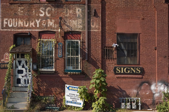 An old foundry, now a sign shop, with several signs.
