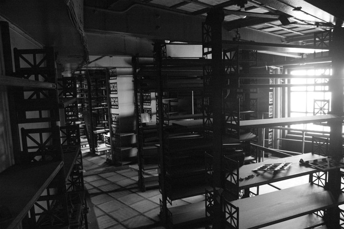 Light streams into a room of empty bookcases.