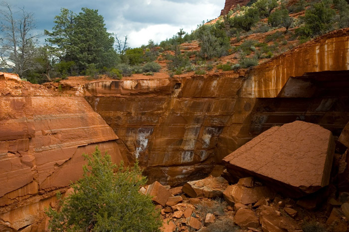 A huge pit of red rock, with a large fallen slab.