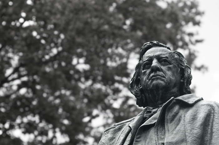 A statue of Henry Ward Beecher, with trees behind it.