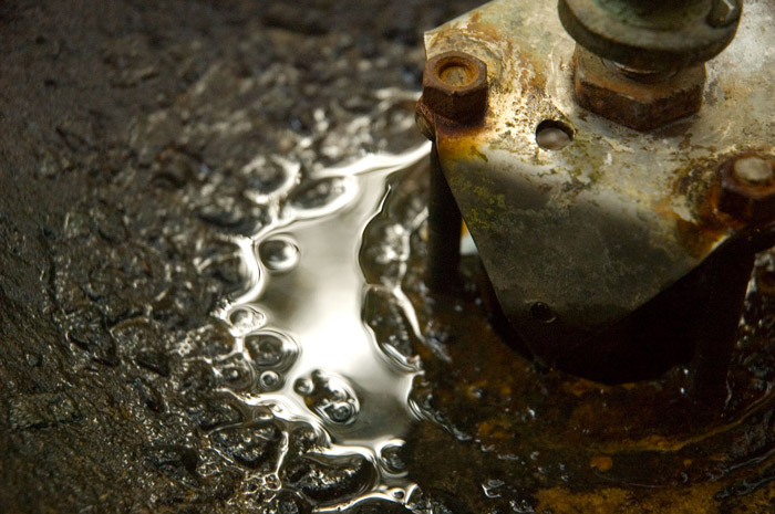 Water has accumulated around a drinking fountain's pump.