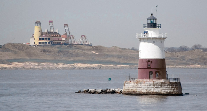 A short lighthouse sits on a tiny reef.