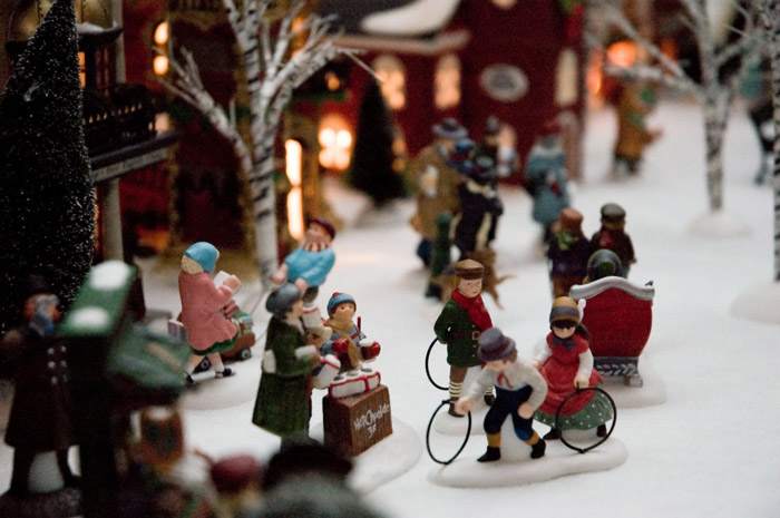 Figurines of people enjoying their village, playing winter games and rushing.