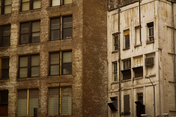 Two buildings' backs show a distinct lack of paint and attention.