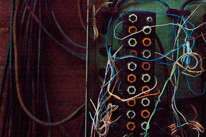 A box of telephone connections is opened, revealing colorful wires and screws.