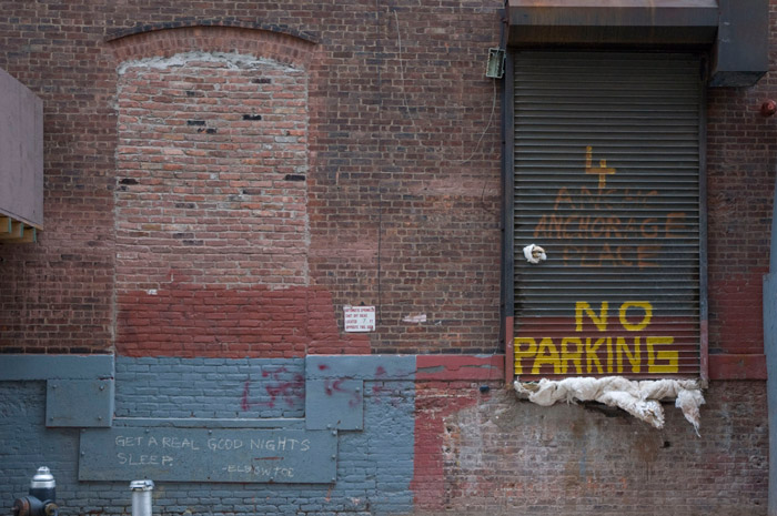 Graffiti next to a loading dock reads, 'Get A Real Good Night's Sleep.'