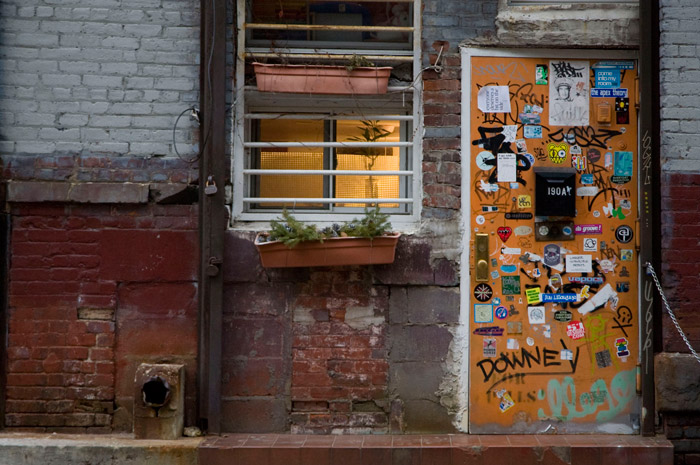 A front door seems covered with scores of stickers and scrawls.