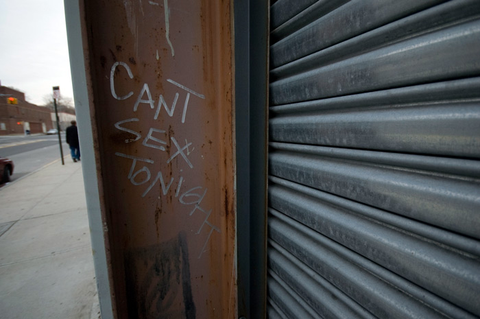 A support beam has been graffitied with the message 'Cant Sex Tonight.'