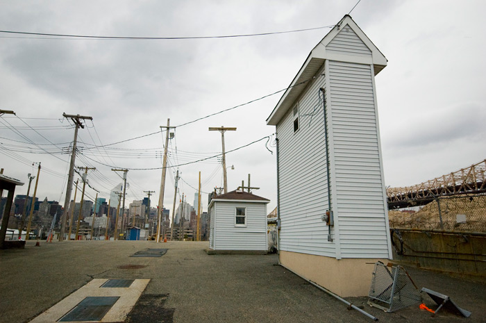 A training facility for the electric company features a skinny building built merely to house meters, and a farm of electrical poles.