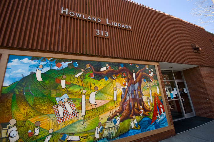 A colorful mural shows a tree filled with books, and people harvesting them.