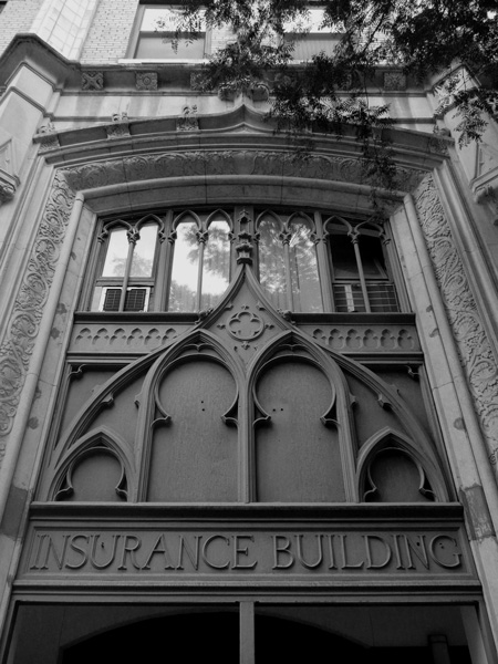 An ornate gothic building rises to the sky, with 'Insurance Building' written over its entrance.