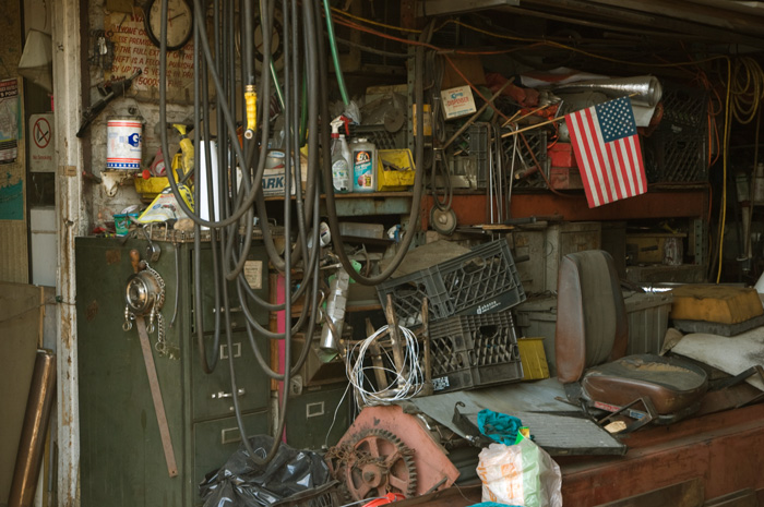 A small American flag stands out amidst filing cabinets, milk crates, tubing, and other mish mosh.