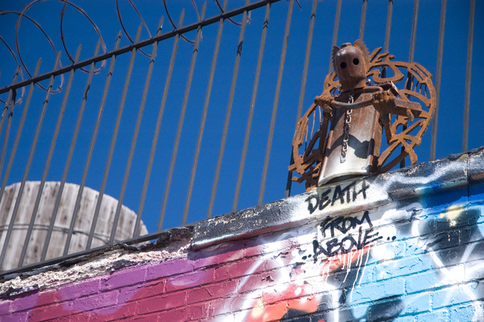 A threatening metal figure at the top of a building holds a club; the words 'Death From Above' are painted below it.