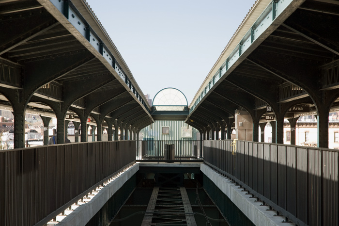 Two elevated subway platforms converge in the distance, but there's an imbalance between them.