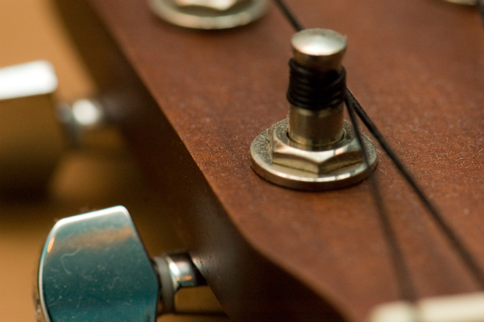 A close-up shot of the tuning machine on the head of a ukulele.